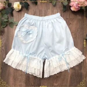 Light blue cotton lolita lace bloomers with iconic heart-shaped lace applique and coordinating pale blue satin bow, featuring multi-tiered ruffled lace leg hem with matching ribbon ties, flat lay overhead shot on wooden tabletop with rose flower decorations, sweet lolita aesthetic
