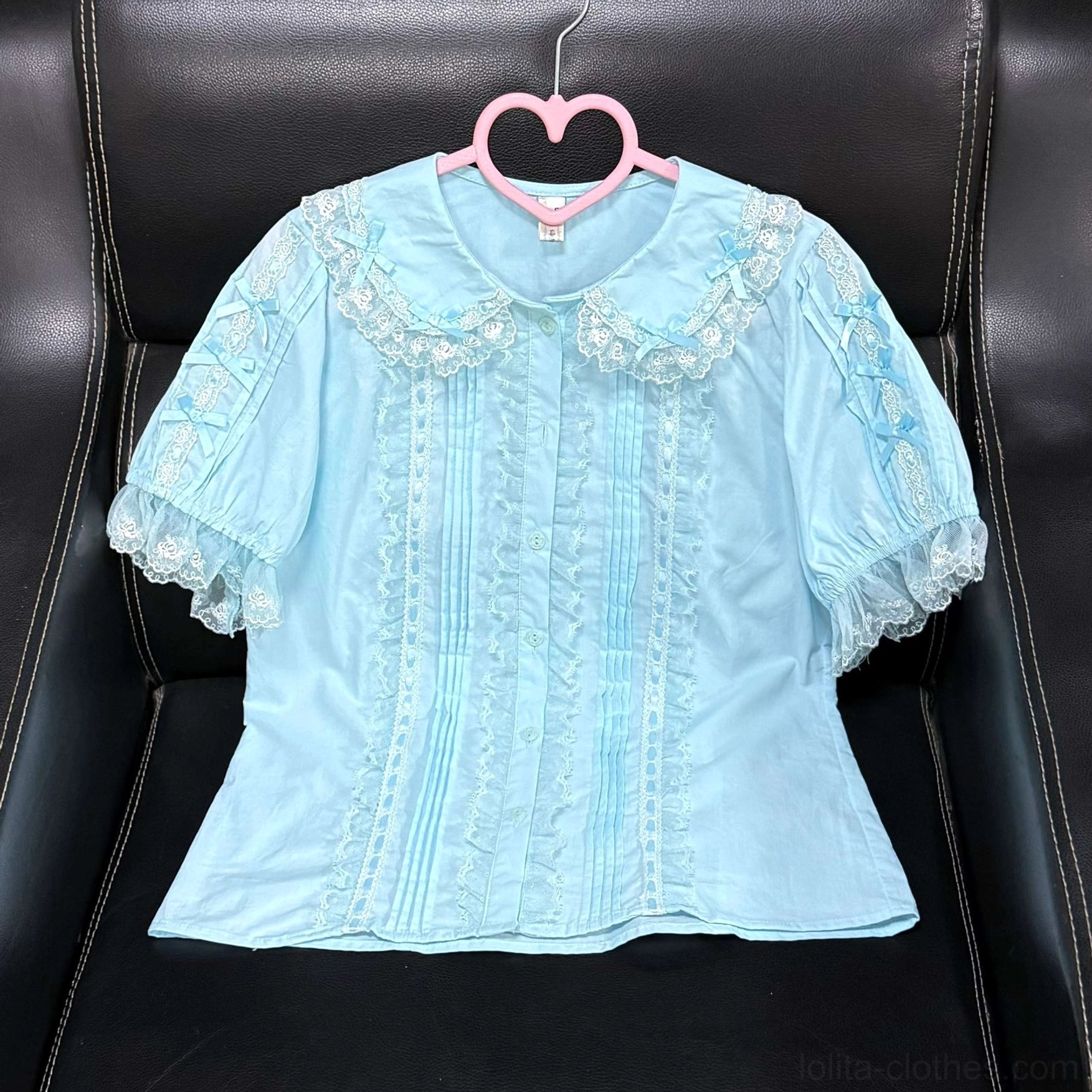 Light blue sweet lolita cotton blouse with lace peter pan collar front pintuck details on black sofa background