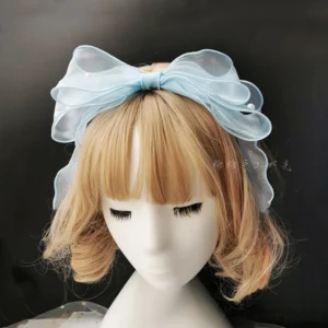 Light blue handmade organza bow lolita headband with pearl embellishments displayed on mannequin with short blonde curly wig, multi-layered sheer fabric with satin-trimmed edges