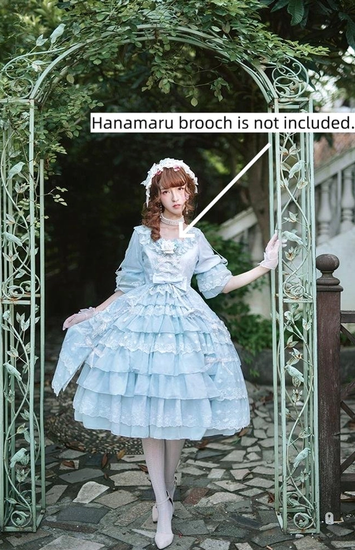 Light blue Sweet Lolita OP dress with ruffled tiered skirt and lace-trimmed bodice, front three-quarter view at iron garden arch