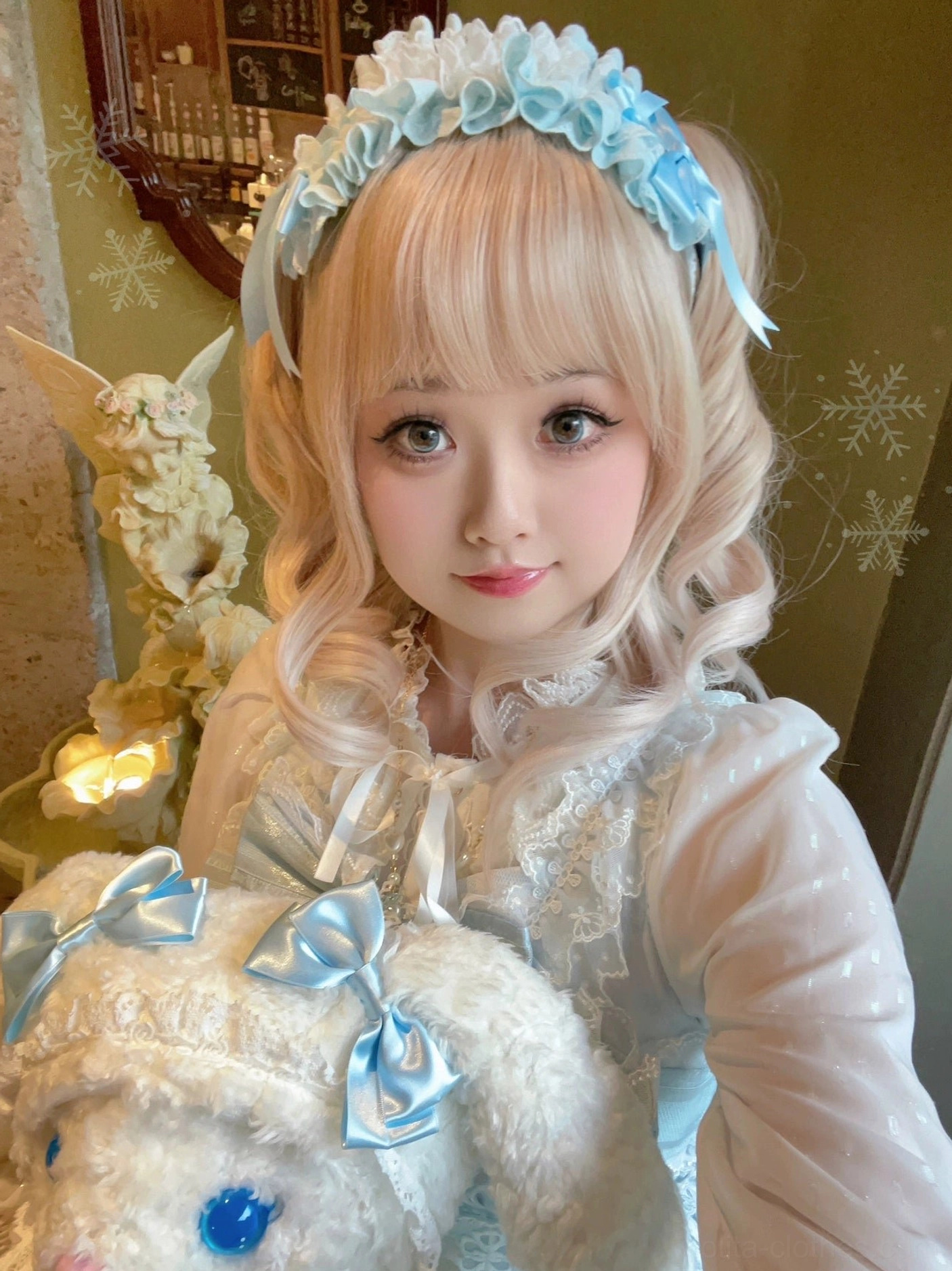 Light blue and white sweet Lolita ruffled lace headband with matching satin bow decoration worn by blonde curly-haired model in vintage indoor setting