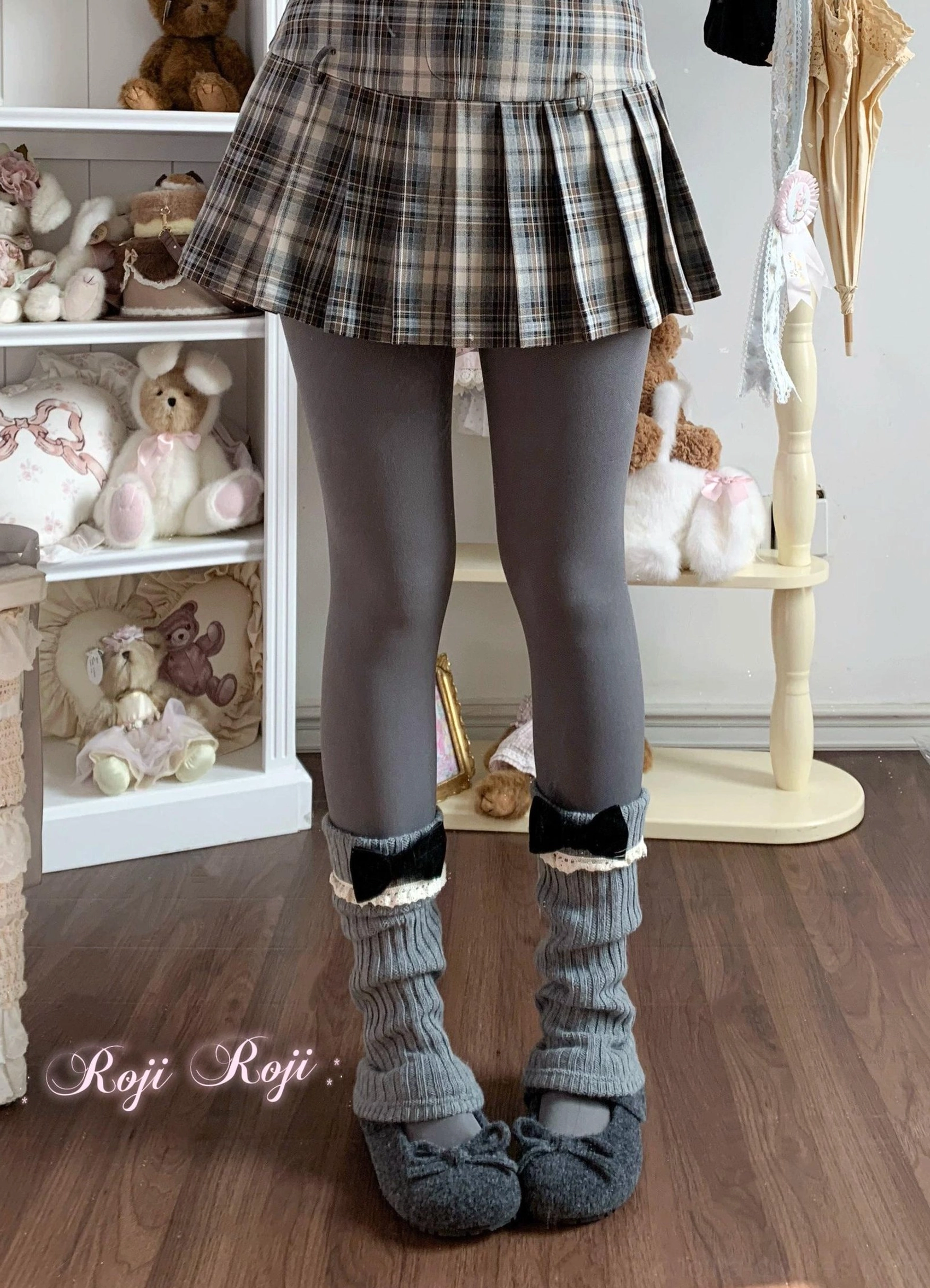 Light gray winter fleece pantyhose with gray knit leg warmers black bow and gray loafers low angle close-up shot