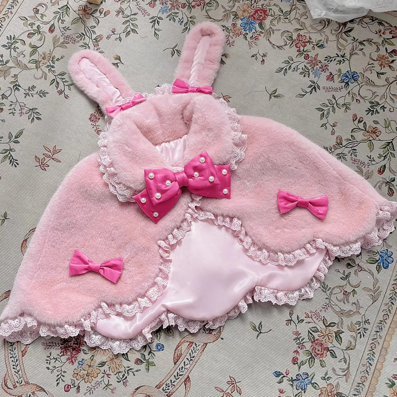Light pink Lolita cape with strong pink pearl bow rabbit ear design winter plush shawl flat lay