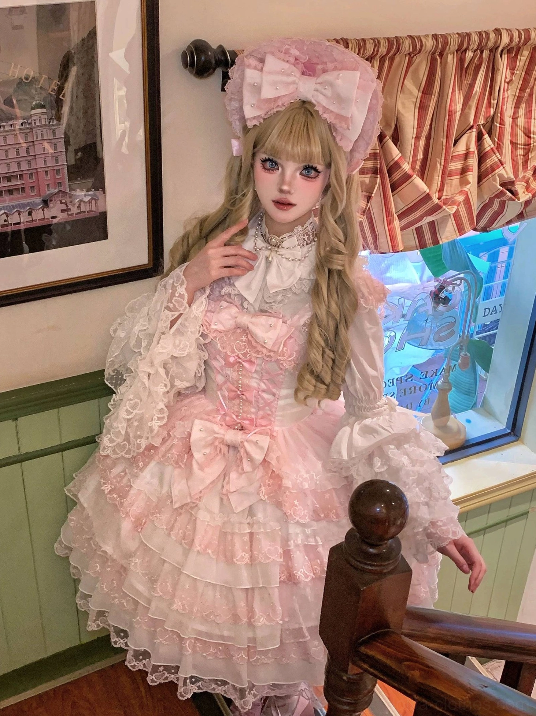 Side profile of light pink Sweet Lolita princess blouse with lace long sleeves, corset bodice featuring bow details, and tiered ruffled skirts layered design