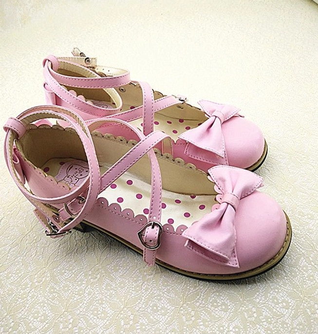 Light pink Lolita low heel princess shoes with pink cross ankle straps and buckles, matching pink bow decoration at vamp, scalloped shoe edge, and cute polka dot inner sole