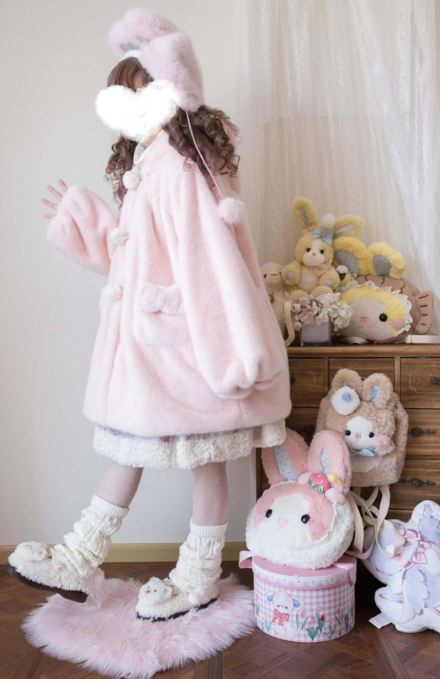 Light pink lolita winter thickened fleece overcoat with bear ear hood and pom-pom buttons, showing soft plush fabric texture and cute kawaii styling details