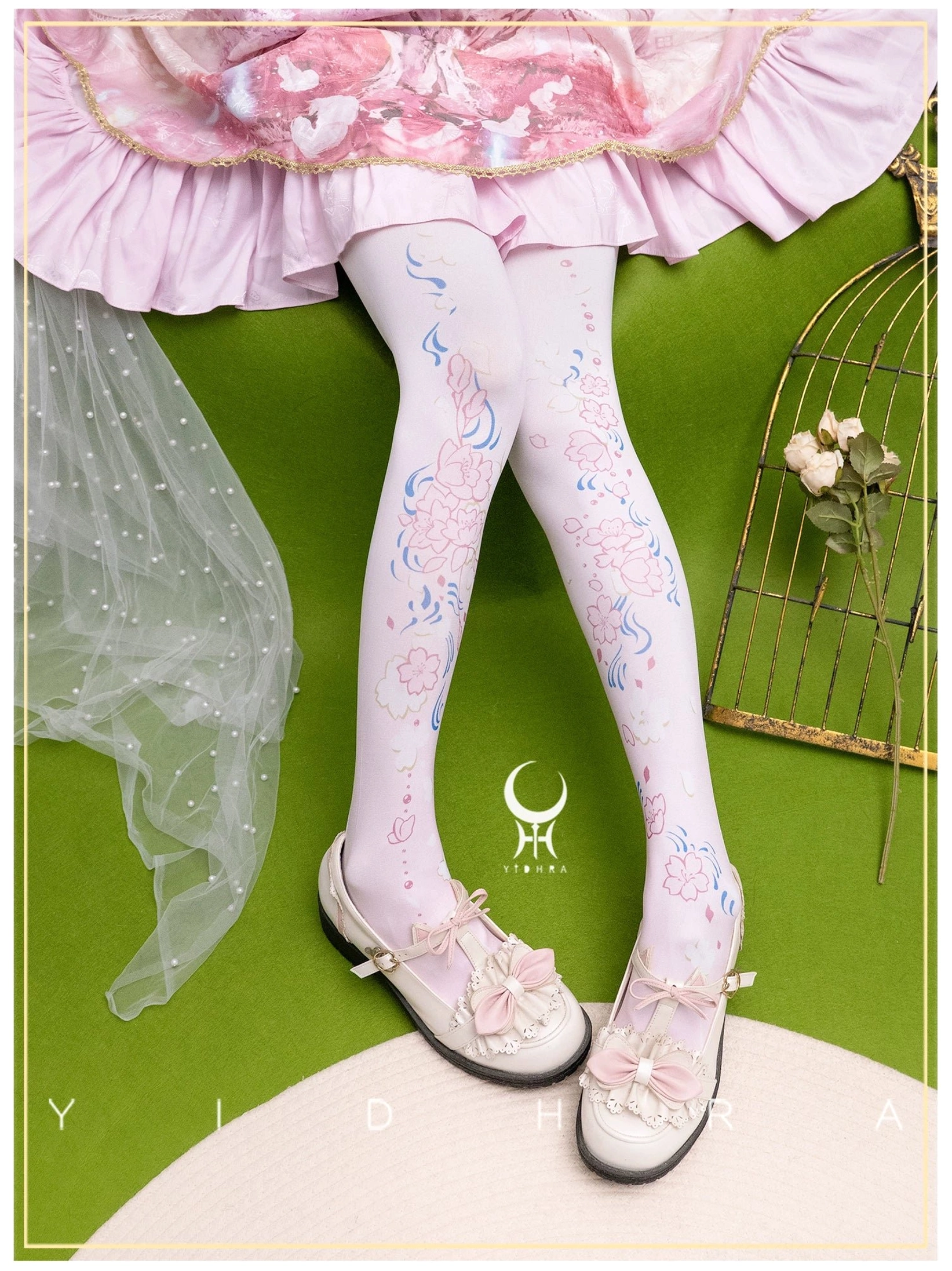 Light pink sakura lolita pantyhose 120D full leg print effect displayed in crossed leg pose with pink frilly skirt white bow shoes overhead angle