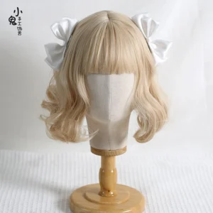 Light pink Sweet Lolita satin bow hair clips displayed on blonde curly wig mannequin close-up showing smooth satin fabric and cute compact bow styling