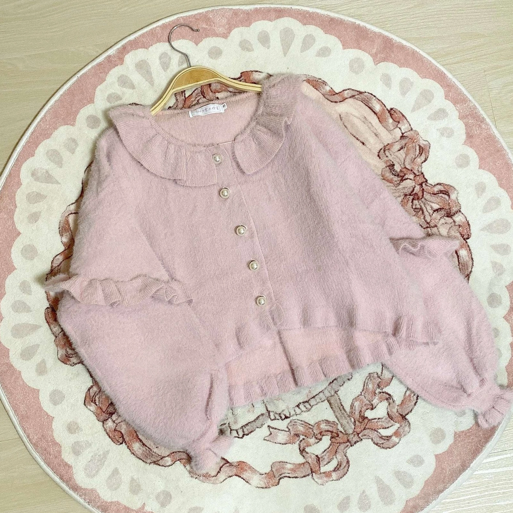 Light pink sweet lolita fuzzy cardigan with matching coordinate styling outdoor scene pastel aesthetic