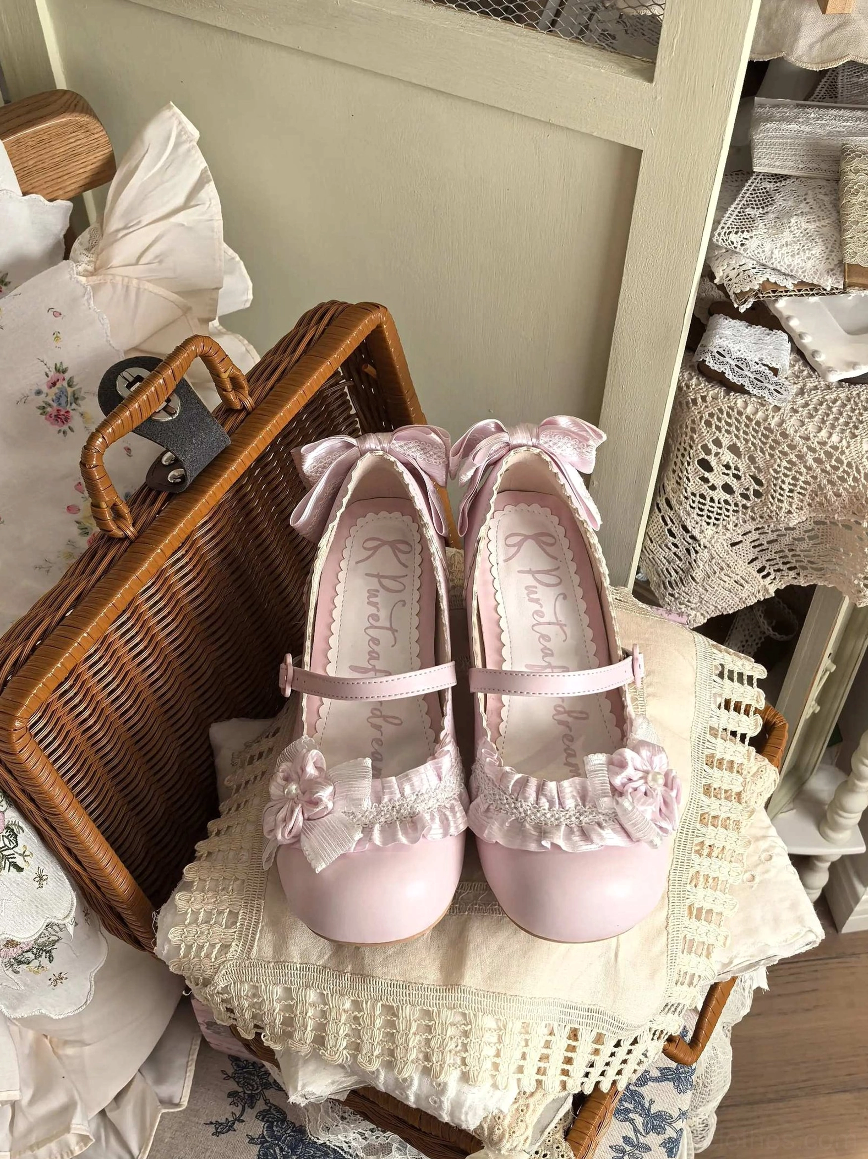 light pink sweet lolita mary jane round toe heel shoes flat lay wicker suitcase ruffled floral trim ankle bow branded footbed