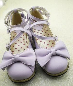 Light purple Lolita low heel princess Mary Jane shoes with cross ankle straps and metal buckles, featuring oversized bow decoration and polka dot inner sole, oblique front view