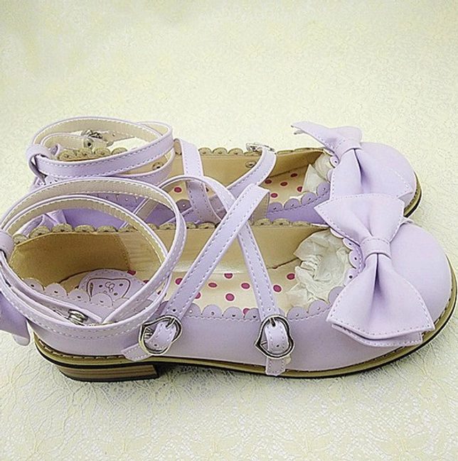 Light purple Lolita low heel princess Mary Jane shoes back view showing cross purple ankle straps with buckles, large purple bow front decoration, and patterned polka dot inner sole