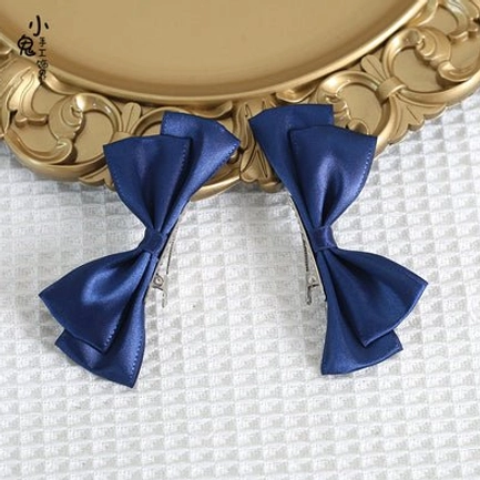 Light purple Sweet Lolita satin bow hair clips in flat lay display on ornate golden tray with checkered fabric background showing lavender bows and metal alligator clips