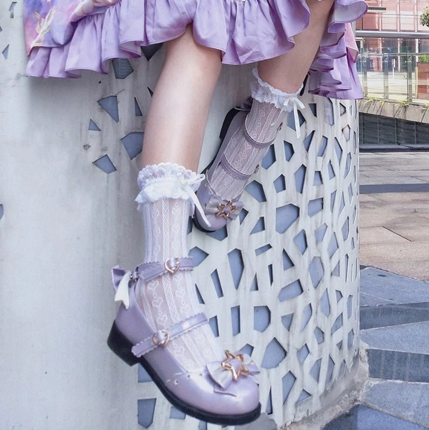 Close-up side view of light purple sweet lolita mary jane shoes with star gold hardware ankle buckle strap worn with frilly lace socks and purple ruffled lolita skirt
