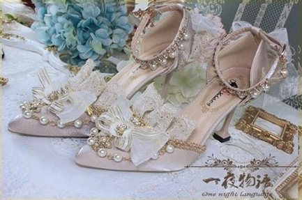 Light yellow pointed toe Lolita wedding heels overhead flat lay view, featuring pale yellow satin upper, yellow ribbon bow with pearl embellishments, delicate lace collar trim, gold edge detailing, and elegant thin stiletto heel