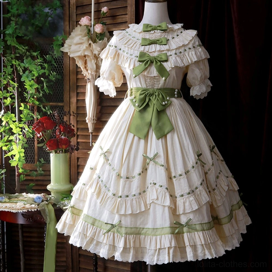 Full length lily of the valley country lolita OP dress front view showing removable waist bow tie option, tiered ruffle skirt, and complete silhouette with sage green accents