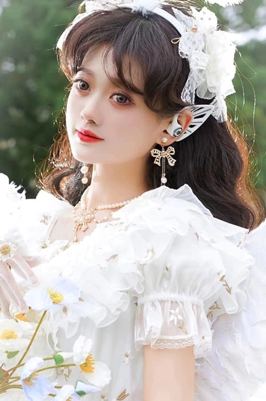 Model wearing complete lily of the valley pearl Lolita jewelry set half-body portrait shot showing layered pearl necklace matching earrings paired with white ruffled Lolita dress floral hair accessory outdoor daisy garden background