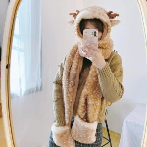 Winter lolita plush 3-in-1 set with reindeer antler design worn in mirror selfie, featuring spotted fawn fleece hood, integrated scarf, and matching gloves on model wearing cable-knit sweater and plaid skirt