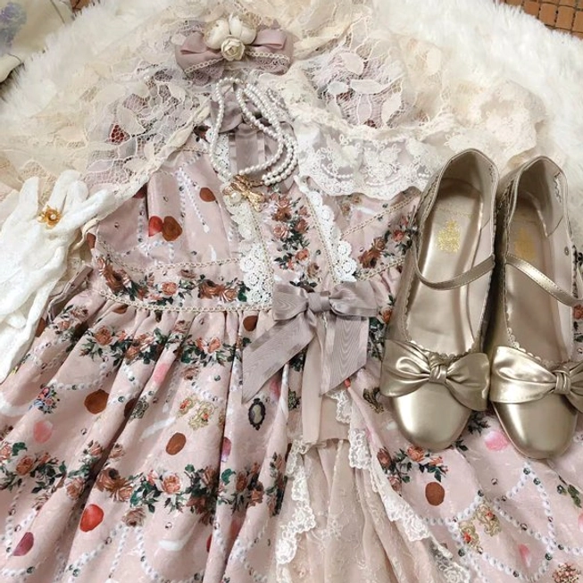 Flat lay composition lolita fashion accessories including pearl necklaces on pink floral print lolita dress with golden Mary Jane shoes with bow details, top-down shot, soft light indoor background, styling inspiration