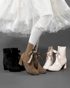 Model wearing retro lolita ankle boots with white embroidered tulle skirt and sheer white stockings showcasing suede-like upper block mid heel and satin ribbon bow collar details