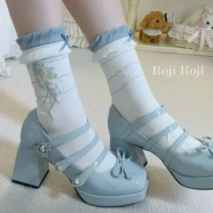 Roji Roji sweet lolita ankle socks featuring white base with blue ruffled cuffs and delicate floral print paired with double-strap light blue Mary Jane heels with gem embellishments front three-quarter view
