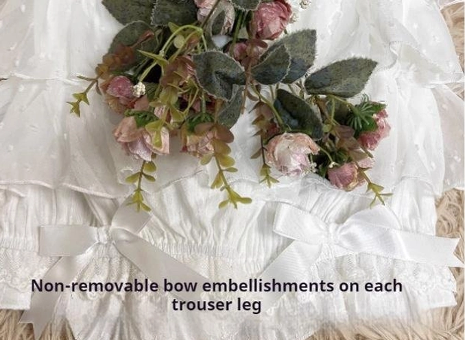 Close-up detail of lolita bloomers showing non-removable satin bows on leg cuffs with layered white ruffled fabric and neat stitch workmanship