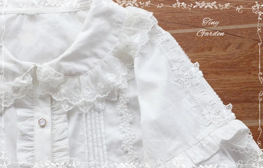 Close-up detail view of white Lolita blouse showing pearl front button, lace ruffled collar trim, and delicate sleeve lace detailing