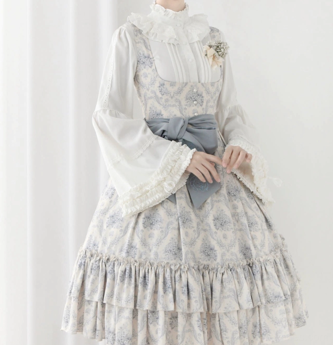 Milky white classic Lolita blouse styled with coordinated blue-print jumperskirt featuring grey bow sash, complete romantic Lolita coordinate on dress form against white background