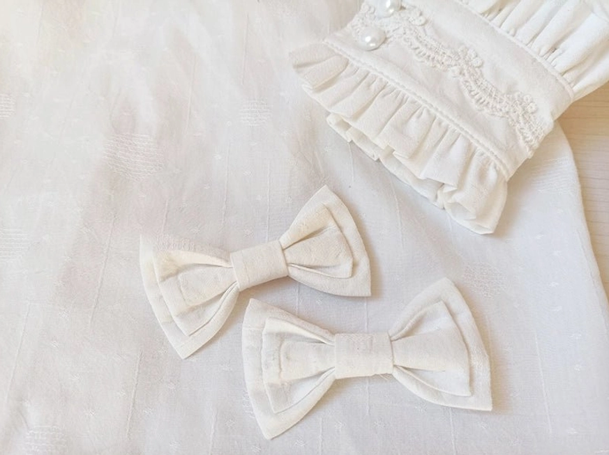Lolita blouse cuffs and detachable bow accessories flat lay showing ruffled lace-trimmed sleeves