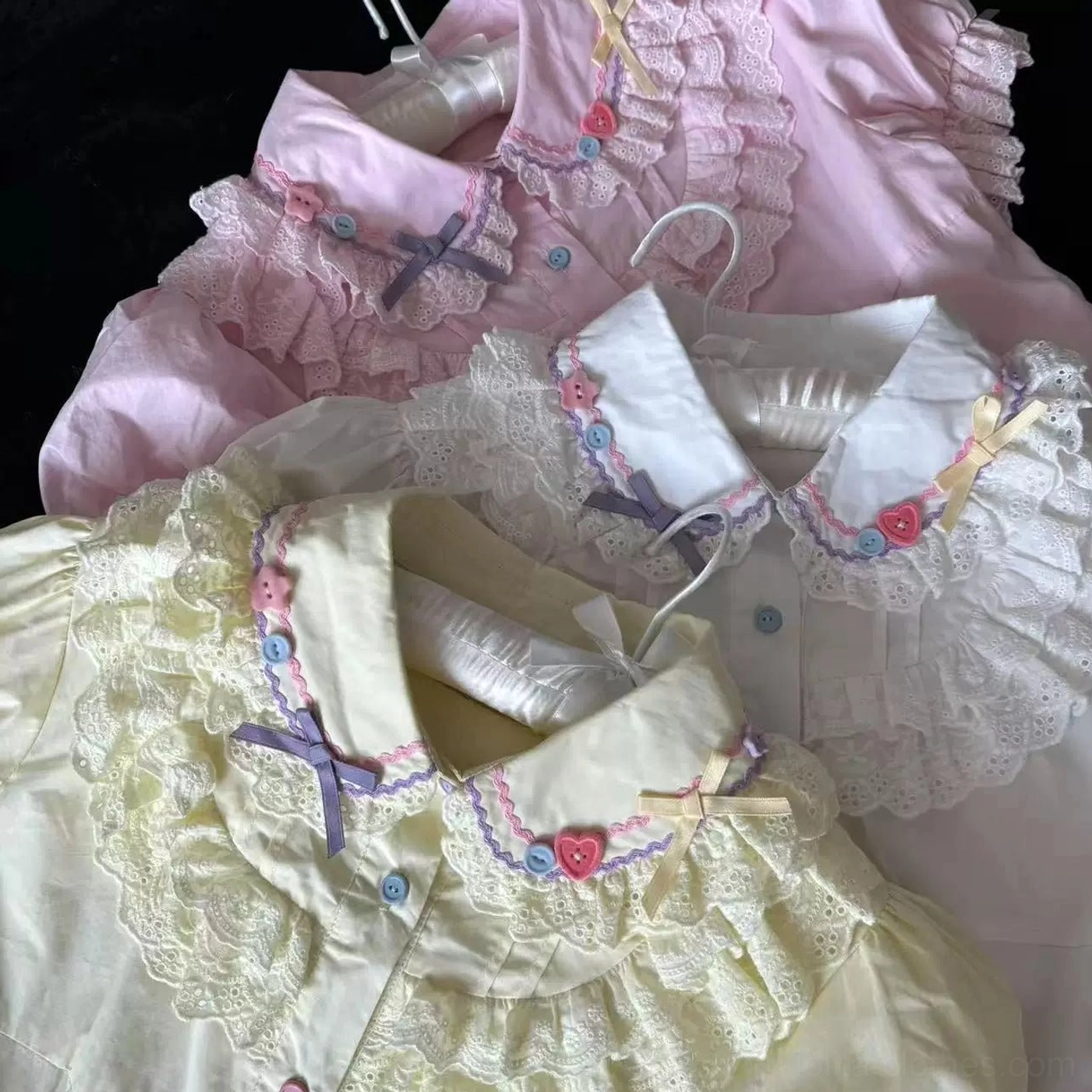 Close-up detail shots of lolita blouses showcasing lace ruffled collars purple decorative bows heart-shaped buttons floral collar trims available in yellow white and pink options
