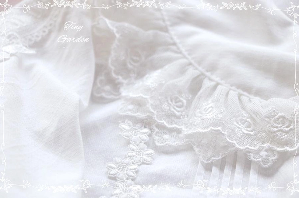 Detailed close-up of embroidered floral lace ruffles and soft cotton fabric texture on sweet Lolita blouse trim detailing