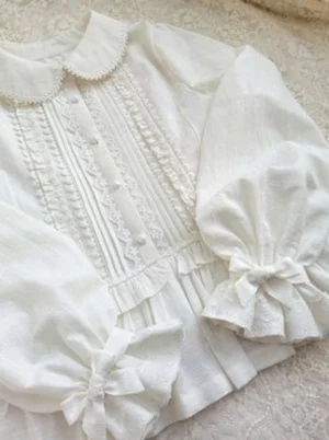Close-up of lace-edged doll collar front lace pleated panels bow-decorated puff cuffs lolita blouse detail