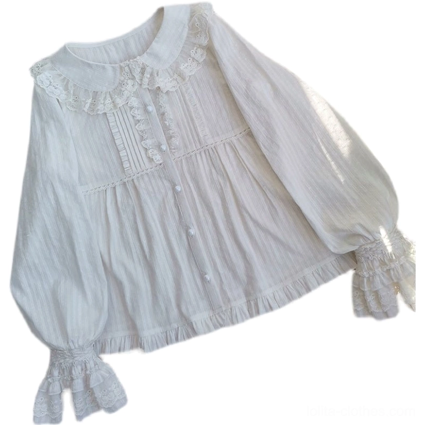 Oblique side angle flat lay of white lolita cotton blouse with peter pan lace collar, layered ruffle cuffs, round front buttons, pleated bodice, and lantern long sleeves on white background