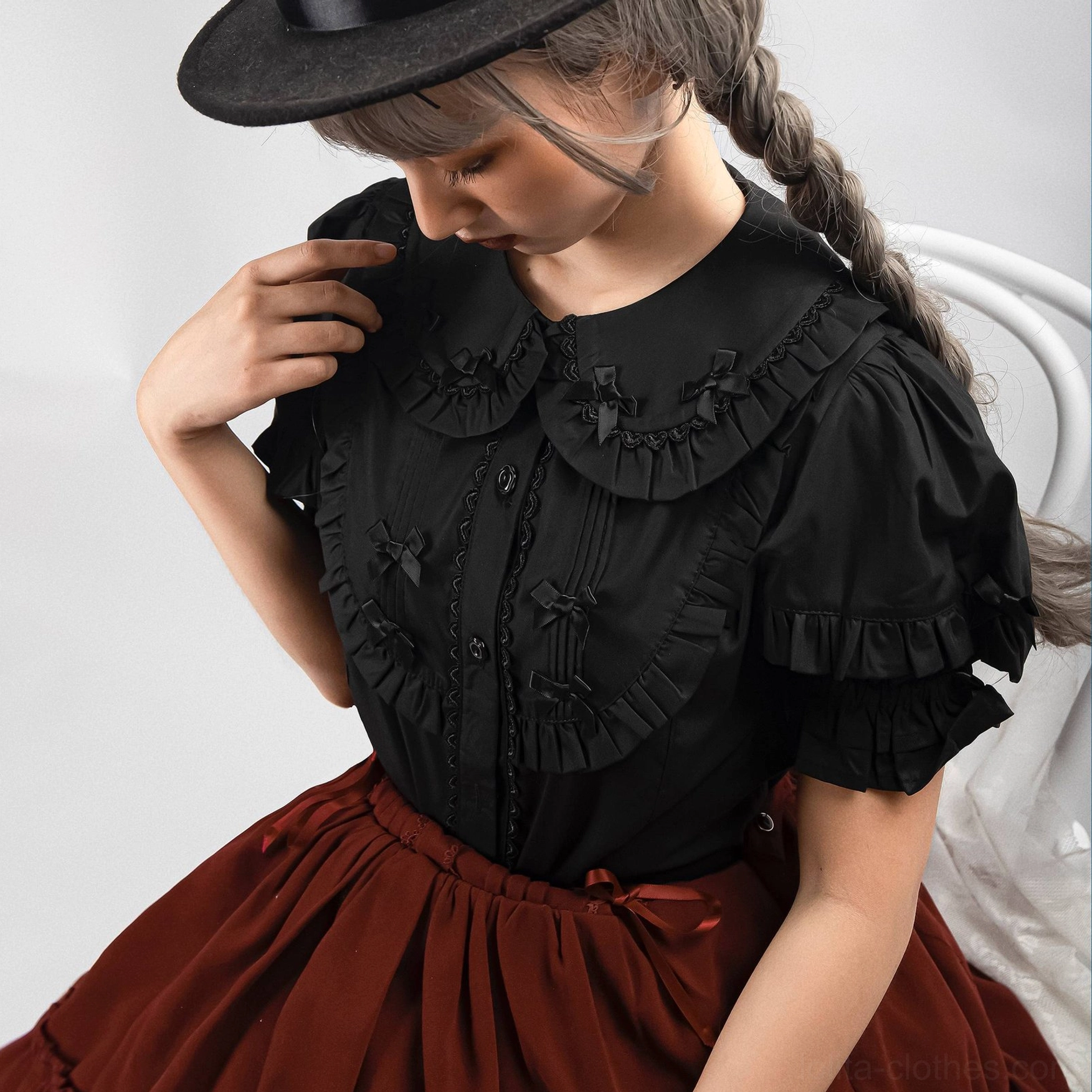 Close-up detail of condensed milk lolita blouse lotus hem design and button front closure with embroidered embellishments