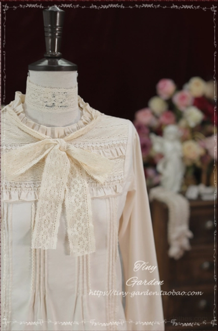 Close-up front view of Lolita blouse neck and upper chest area showing large fabric bow tie, ruffled stand collar, and lace trim on front placket against retro floral studio backdrop