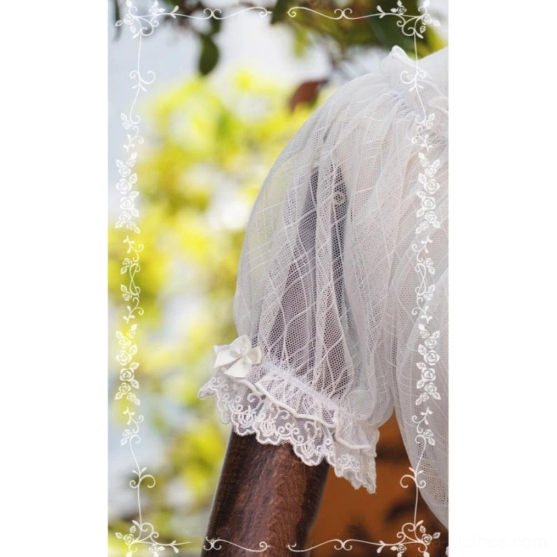 Close-up shot of lolita blouse sleeve detail, featuring lace ruffled cuff with tiny bow accent and rhombus mesh texture, side close-up view with blurred green outdoor garden background