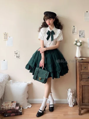 Elegant white ruffled Lolita blouse with black bow and dark green tiered skirt set full-body front view modular convertible sleeves
