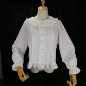 White lolita long-sleeve blouse with heart-shaped gold buttons, vertical body pleats, ruffled collar cuffs and hem trim displayed on studio mannequin