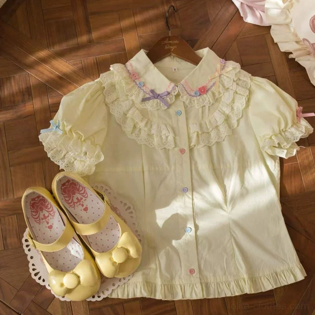 Pale yellow lolita blouse with lace-trimmed ruffled collar and sleeves paired with matching yellow Mary Jane shoes with bow decor heart-patterned insoles flat lay styling