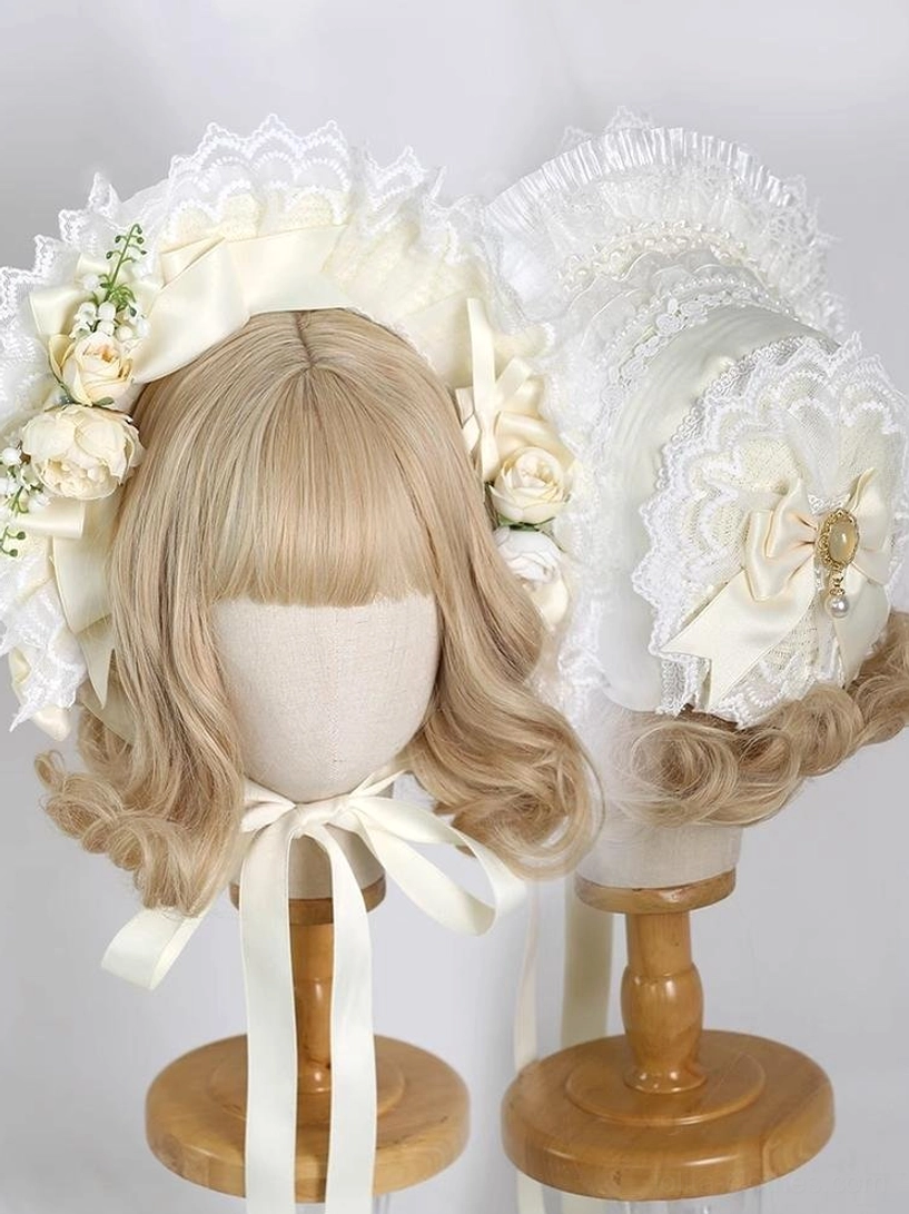 Cream-colored lolita lace bonnet headdress with beige satin bows, vintage golden brooch decoration, and artificial rose floral ornaments on mannequin