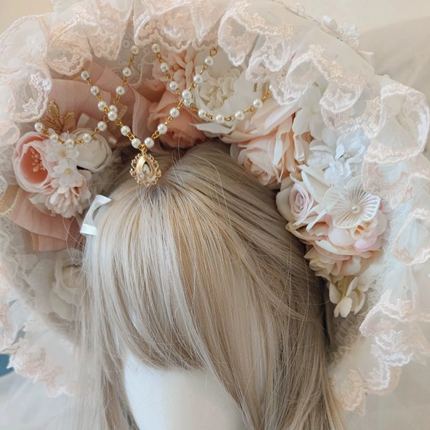 Lolita lace bonnet with central gold gem top ornament, ruffled lace detailing, and artificial flower decorations displayed on mannequin with ash blonde bangs wig, romantic tea party aesthetic