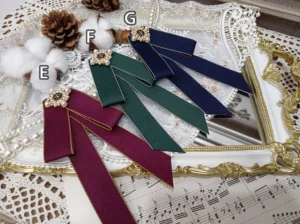 overhead-flat-lay-lolita-bow-brooch-three-colors-wine-red-forest-green-navy-blue-gold-ribbon-trim-flower-shaped-pearl-bead-ornament-vintage-gilt-frame-sheet-music-backdrop