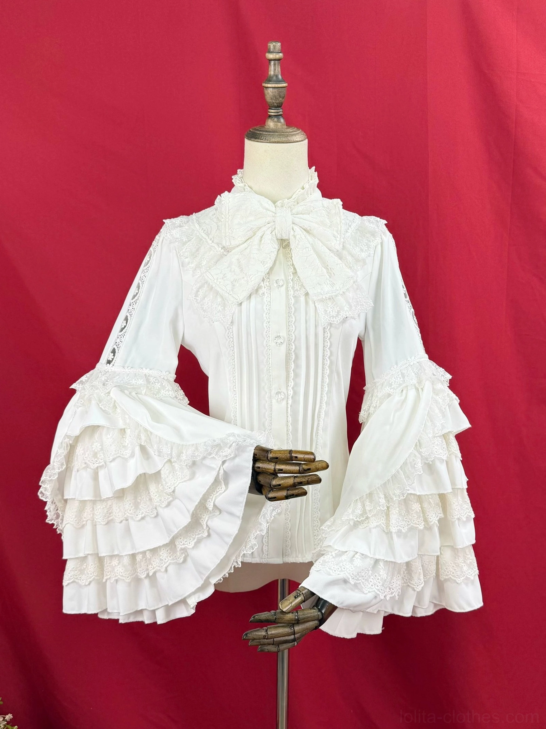 Lolita bow collar blouse left front angled view, cream white fabric, showcasing layered bell sleeve ruffles and fitted waist silhouette with bow neckline