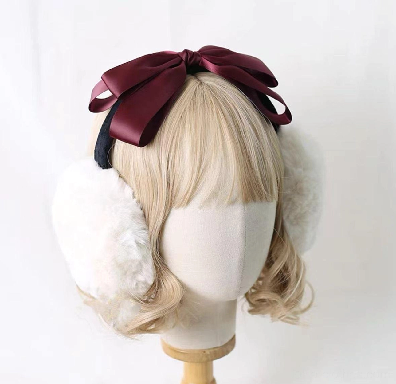 Lolita bow earmuff worn on blonde mannequin showing front view, burgundy red satin bow with white fuzzy earmuffs, classic lolita headdress style