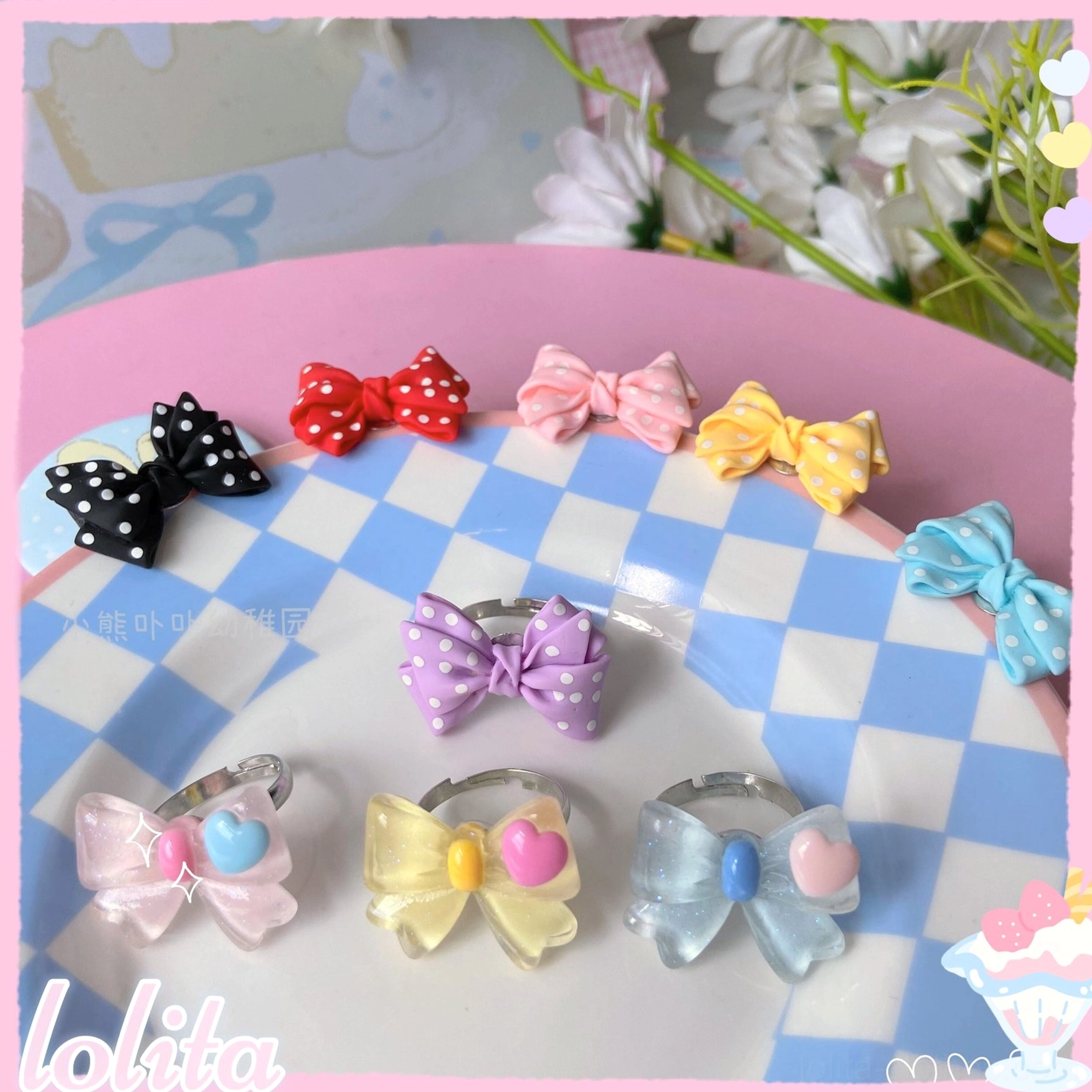 Close-up overhead view of assorted kawaii bowknot finger rings on blue and white checkered ceramic plate showing polka dot and solid bow designs with metal adjustable bases