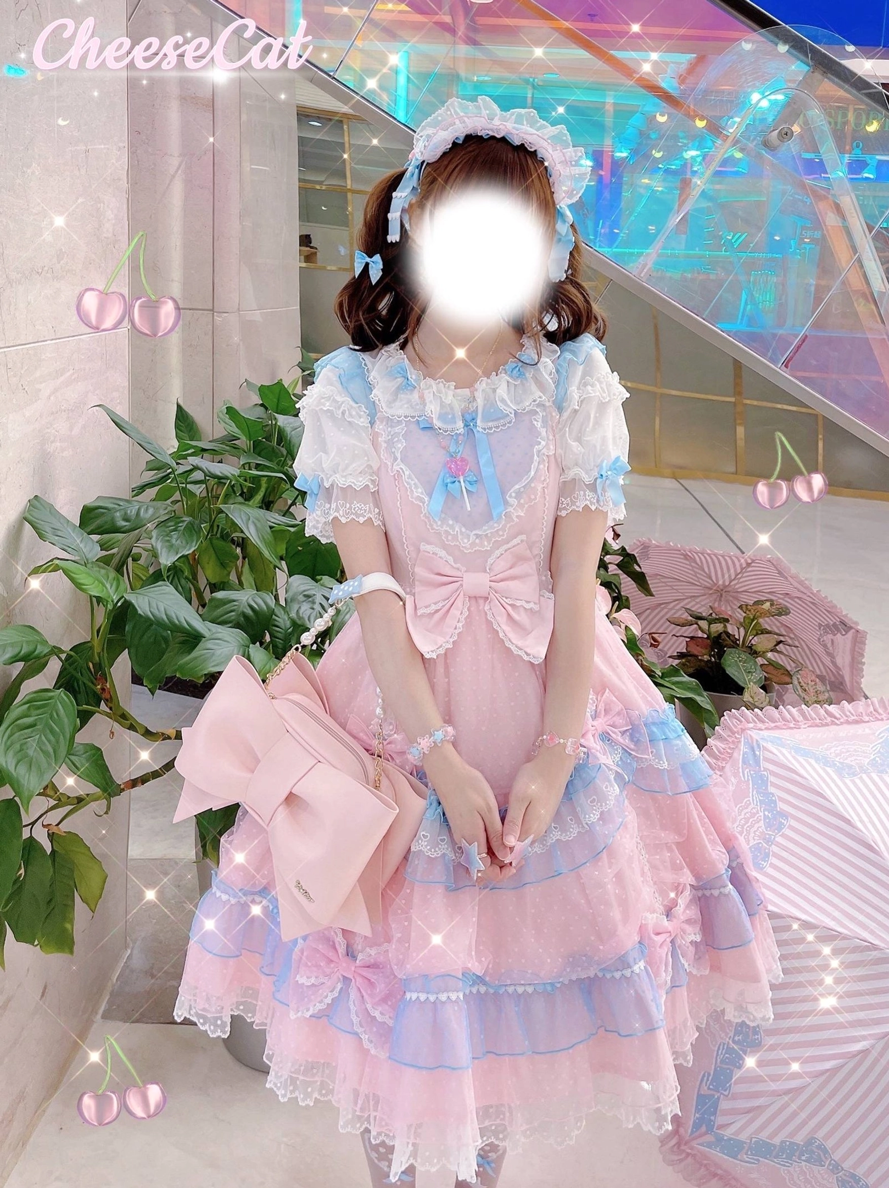 Full-body outdoor shot of girl wearing pink-blue sweet Lolita dress with Lolita matching bracelet on both wrists paired with large pink bow handbag, showcasing complete coordinate styling