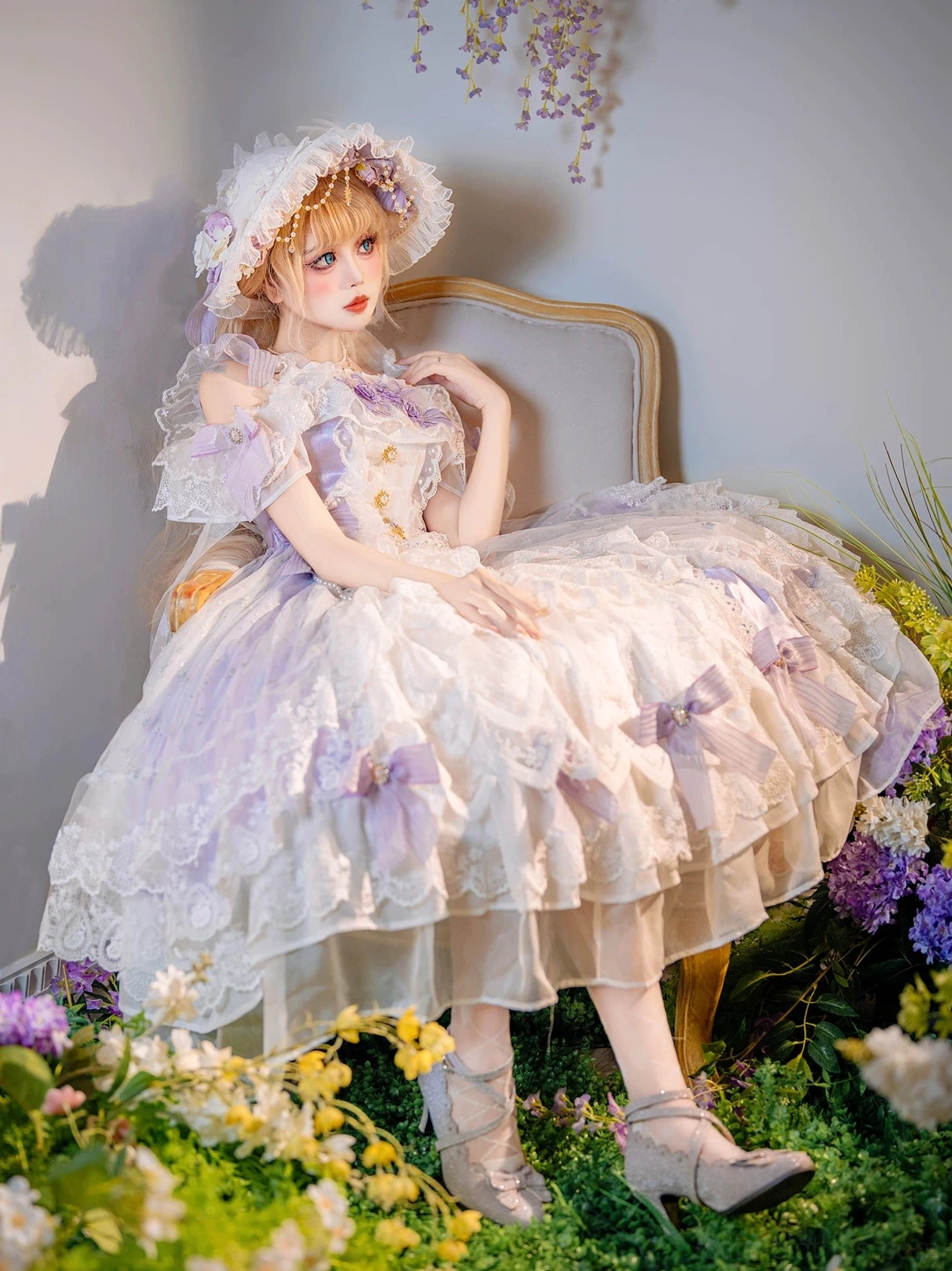 Bridal lolita dress side sitting view highlighting ruffled off-shoulder sleeves, dual-tone fabric construction, delicate lace trims throughout, and full romantic skirt silhouette