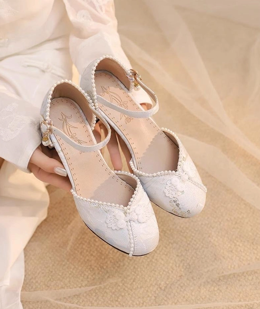 Lolita bridal chunky heel Mary Jane shoes held top-down view floral embroidered toe cap buckle strap