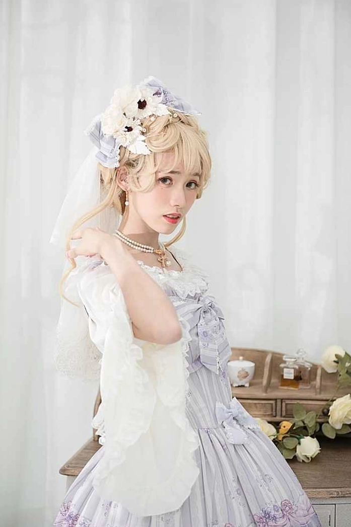 Lolita bride-style model wearing white lace dress with purple embroidery and floral hair veil accessorized with pearl bow necklace, half-body three-quarter view, bright vintage indoor room with flower decorations