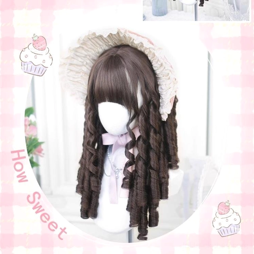 Brown Lolita curly wig displayed through circular mirror frame showing spiral curls and blunt bangs with light purple bow decoration and pink checkered sweet background